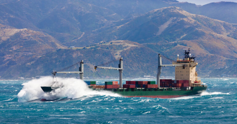 Loaded container freight ship in stormy sea